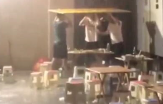 男子暴雨中顶纸板喝酒两小时