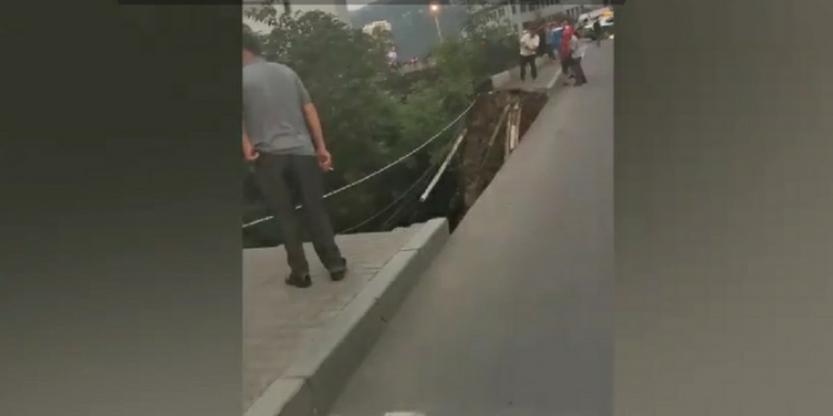 行人正悠闲散步，却突然坠落，只因人行道突然倒塌