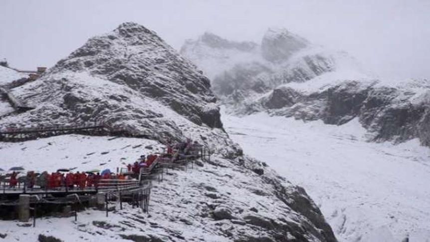 玉龙雪山八月飘雪，雪花散落山间各地